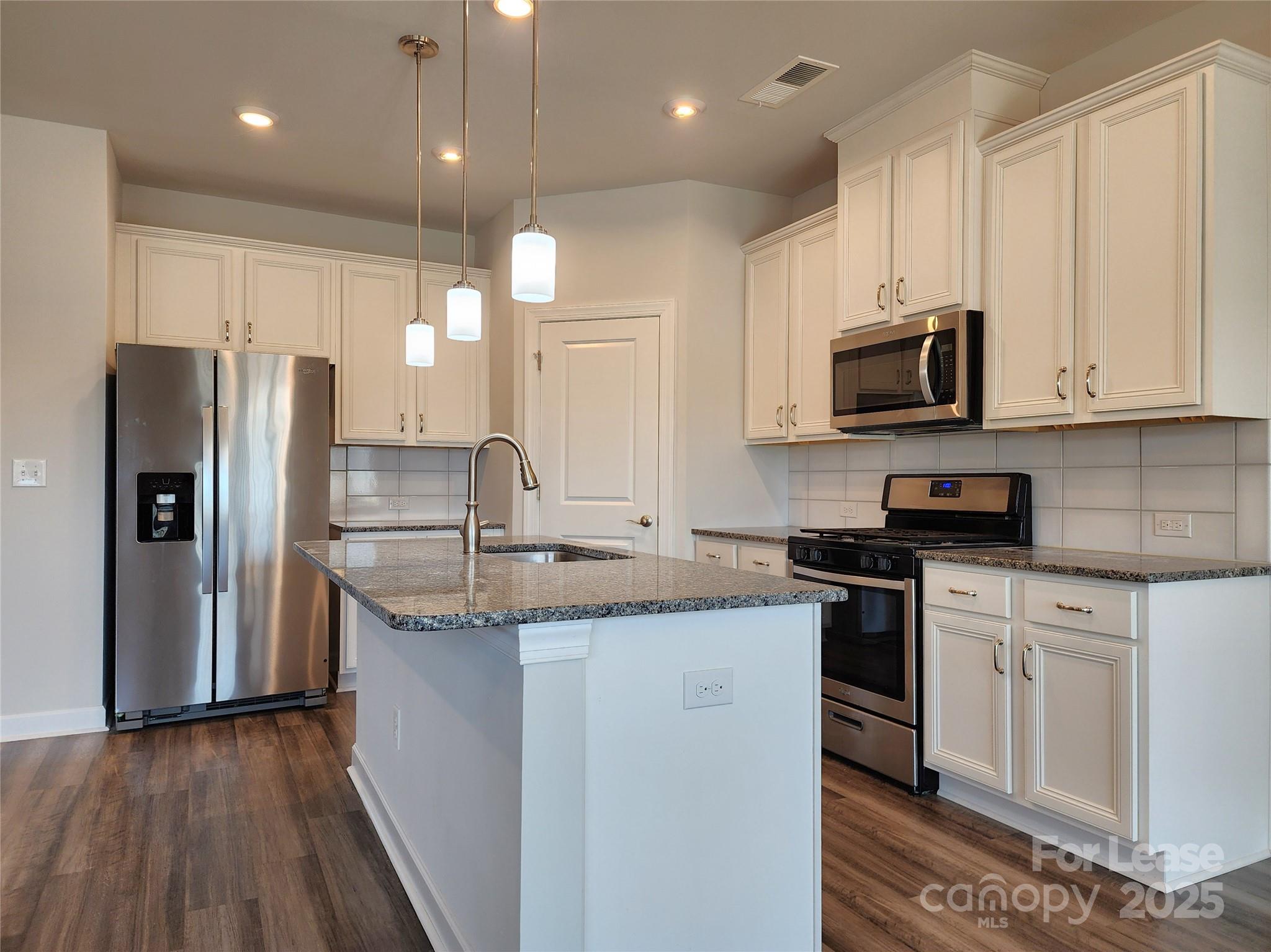 4227 Canopy Creek Drive Denver, NC 28037 - Photo 5 of 33 a kitchen with stainless steel appliances granite countertop a sink a stove a refrigerator a microwave oven with white cabinets and wooden floor