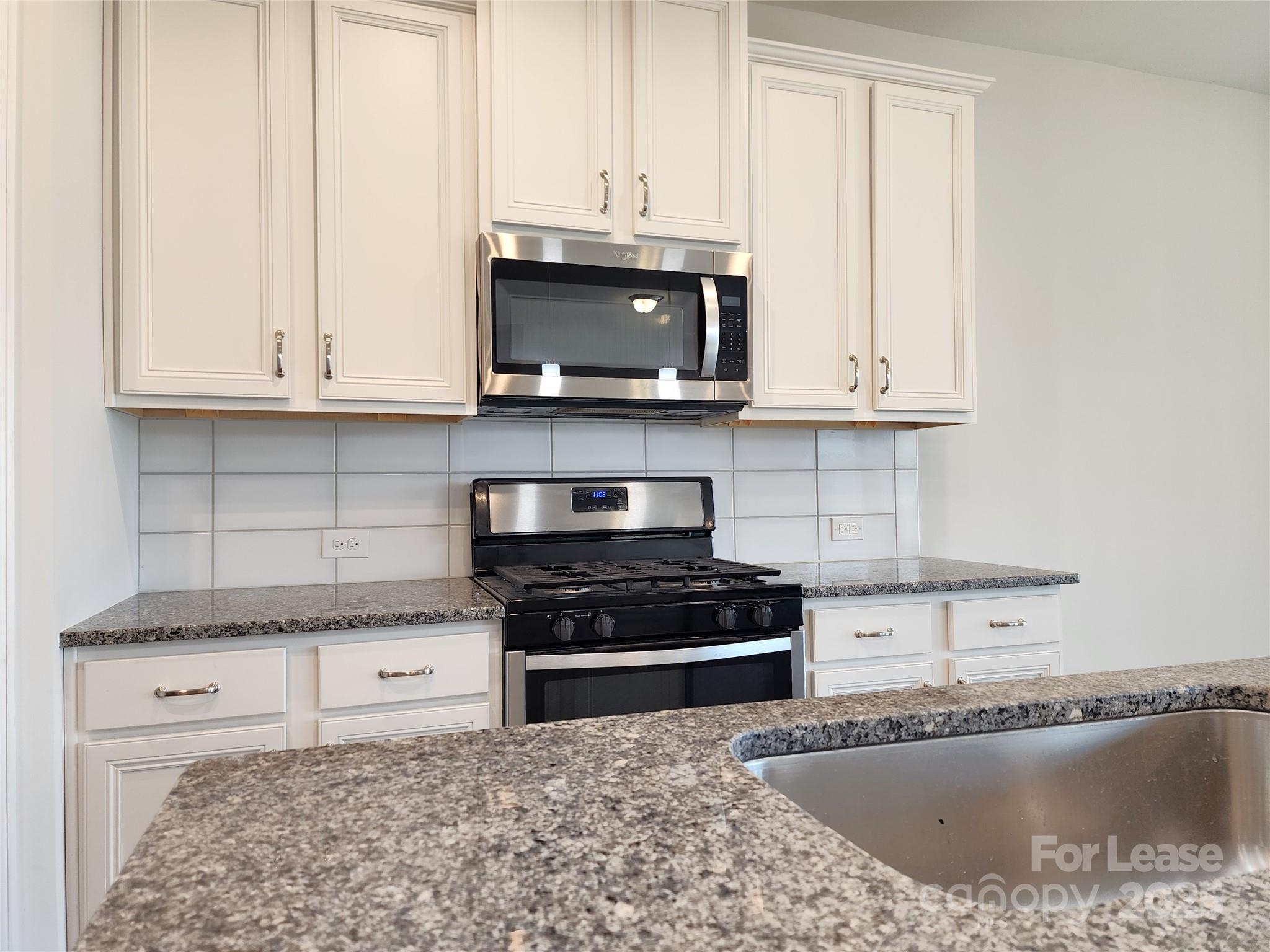 4227 Canopy Creek Drive Denver, NC 28037 - Photo 6 of 33 a kitchen with stainless steel appliances granite countertop a stove a sink and a white cabinets