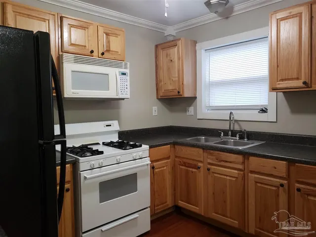 a kitchen with stainless steel appliances granite countertop a stove a sink and a microwave