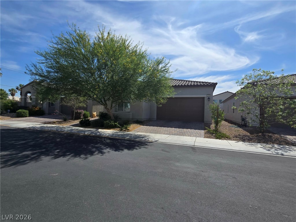 A desert-friendly landscape frames this appealing residence with an integrated garage and tile roof.