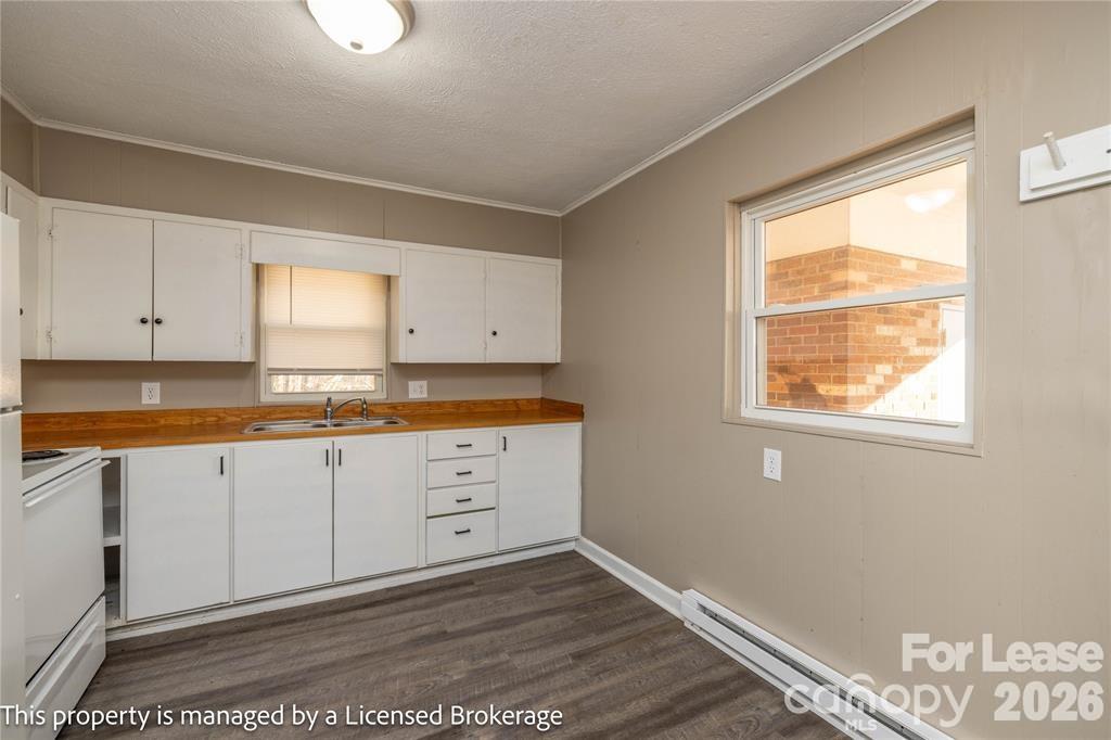 213 Roslyn Road Troy, NC 27371 - Photo 11 of 25 a large white kitchen with granite countertop wooden cabinets