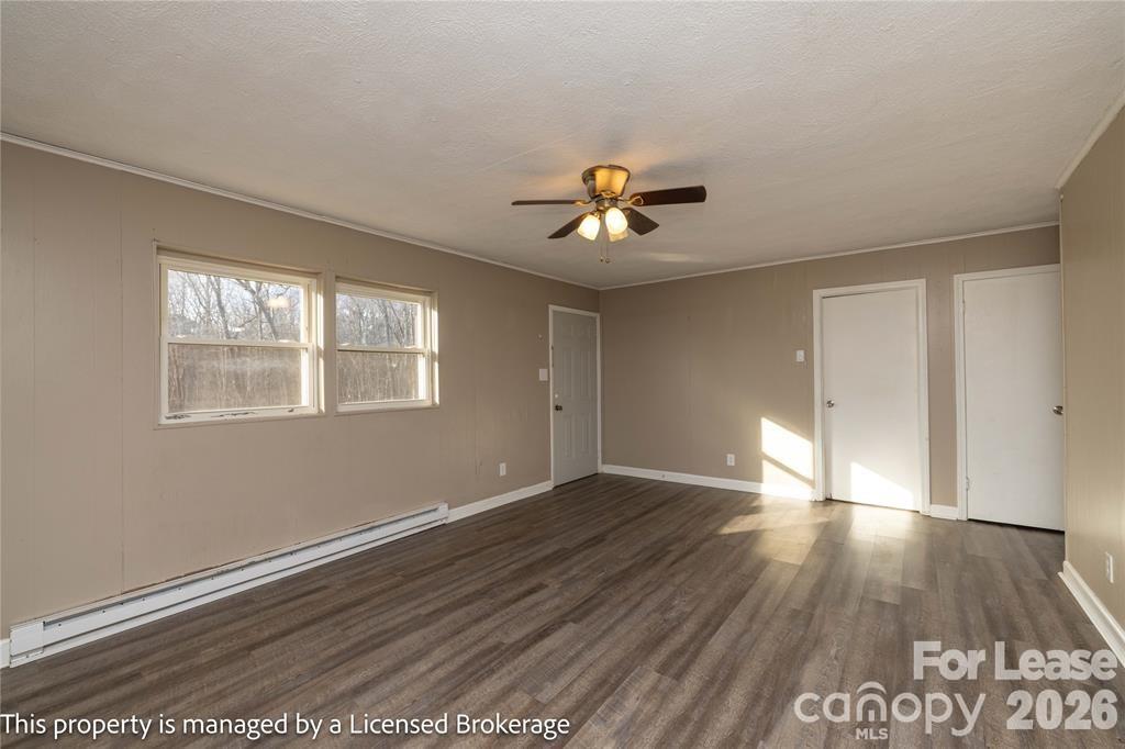 213 Roslyn Road Troy, NC 27371 - Photo 6 of 25 a view of an empty room with window and wooden floor