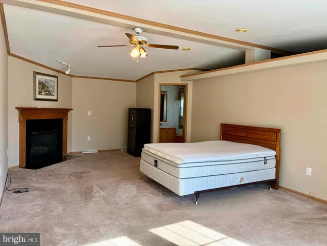 a spacious bedroom with a bed and a ceiling fan