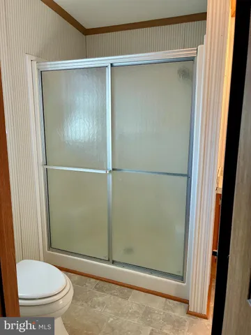 a bathroom with a toilet and a shower