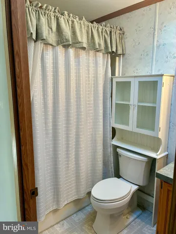 a bathroom with a toilet and a shower curtain