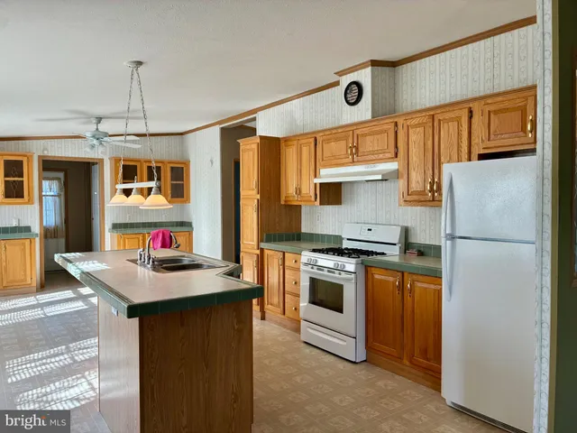 a kitchen that has a stove a refrigerator and a sink
