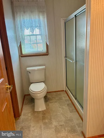 a bathroom with a toilet and a shower