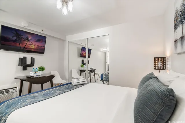 a bedroom with a bed and a flat screen tv