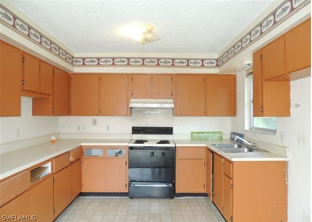 8175 Matanzas Road Fort Myers, FL 33967 - Photo 2 of 12 a kitchen with a stove a sink and a refrigerator