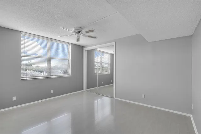 an empty room with a ceiling fan and a window