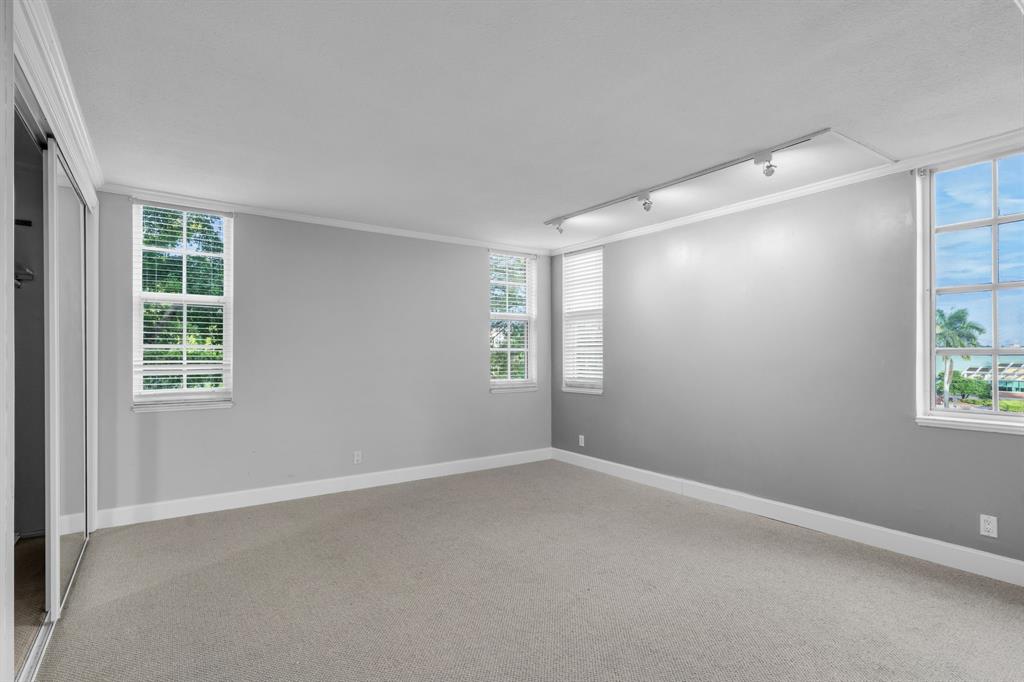 4020 West Palm Aire Drive, Unit 312 Pompano Beach, FL 33069 - Photo 17 of 36 an empty room with windows and closet