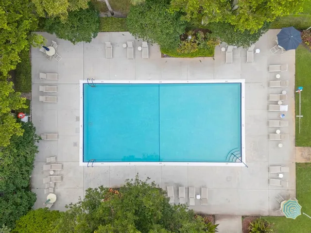 an aerial view of city and lake with trees