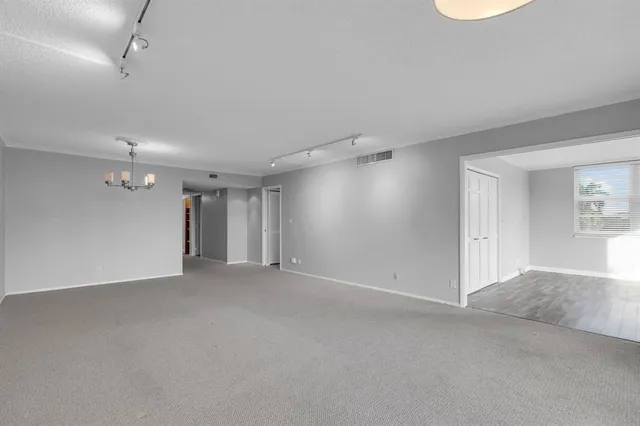 a view of an empty room with chandelier