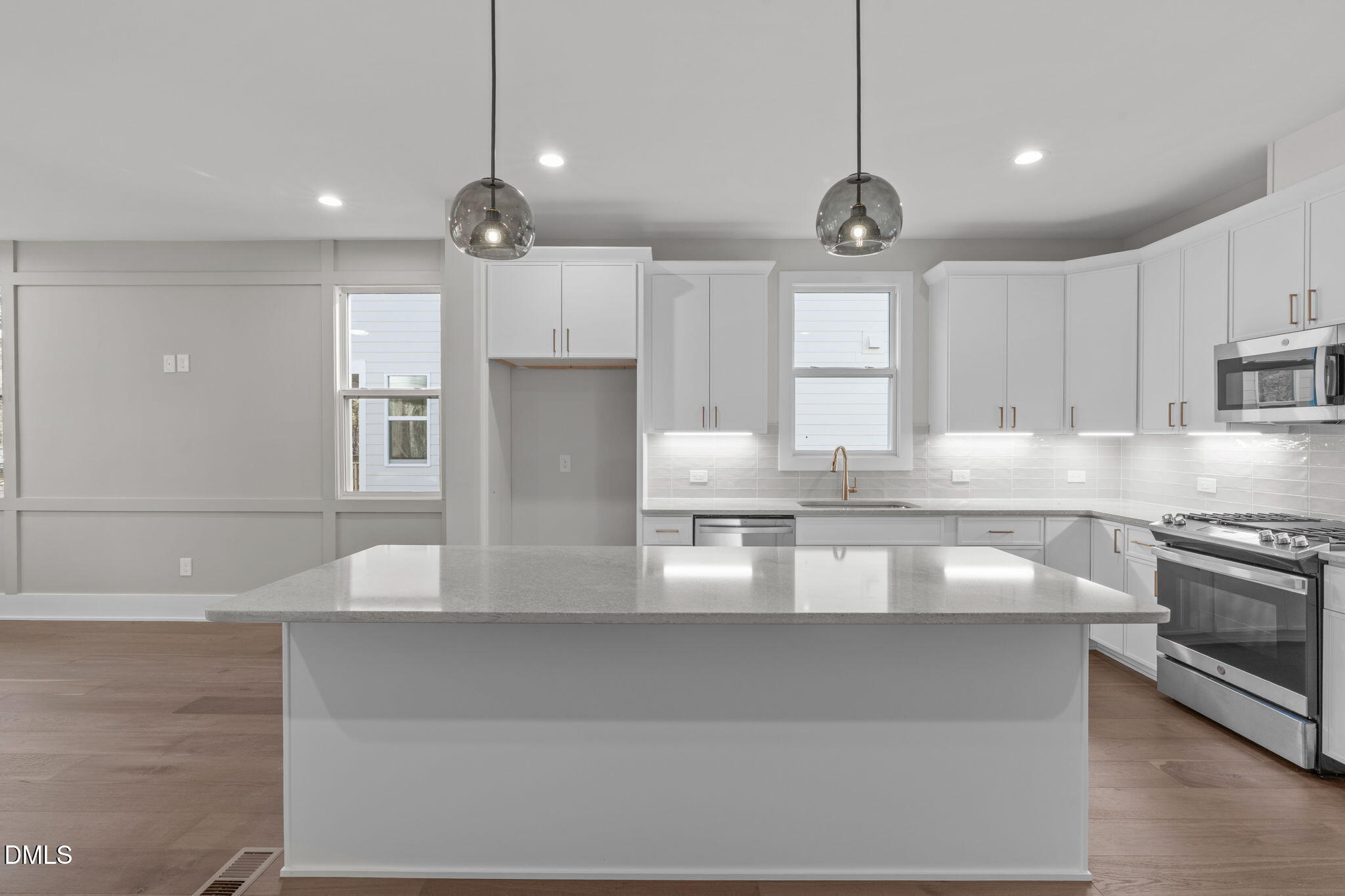 a large kitchen with granite countertop a stove a sink a window and cabinets