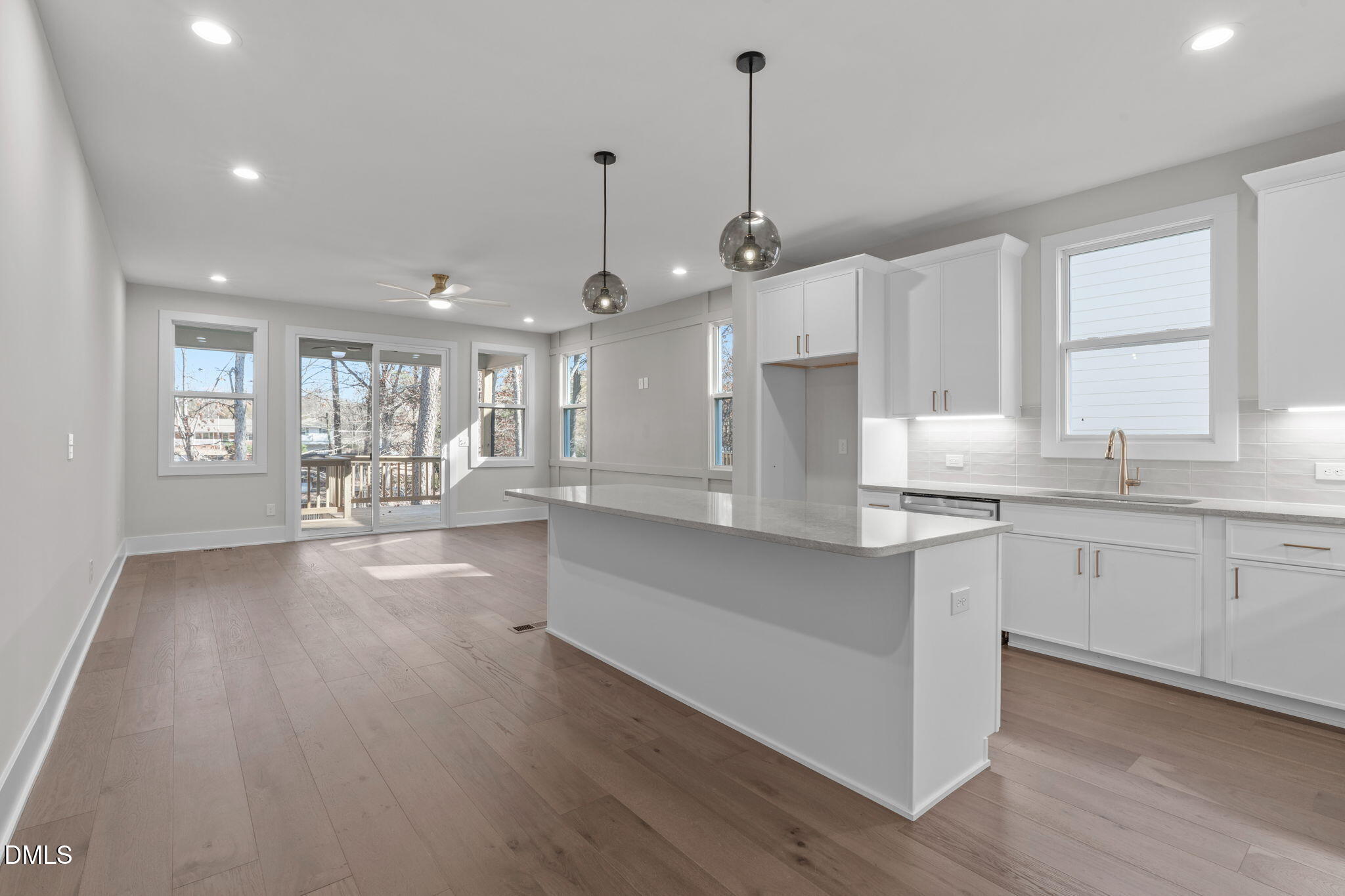 639 Conover Road, Unit B Durham, NC 27703 - Photo 14 of 48 a open kitchen with granite countertop a stove top oven a sink and white cabinets with wooden floor