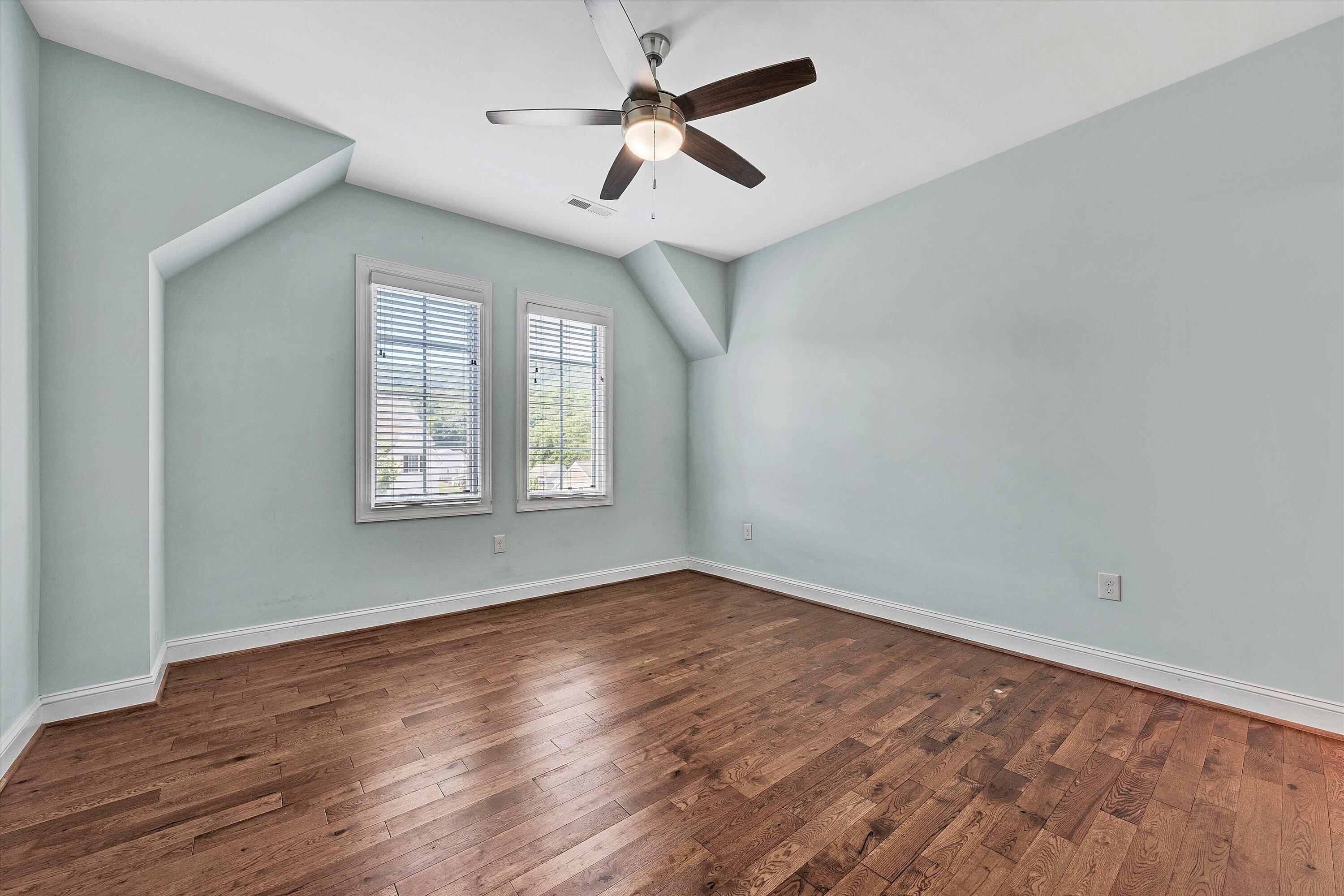 6981 Fairway Ridge Road Salem, VA 24153 - Photo 31 of 53 an empty room with wooden floor ceiling fan and windows