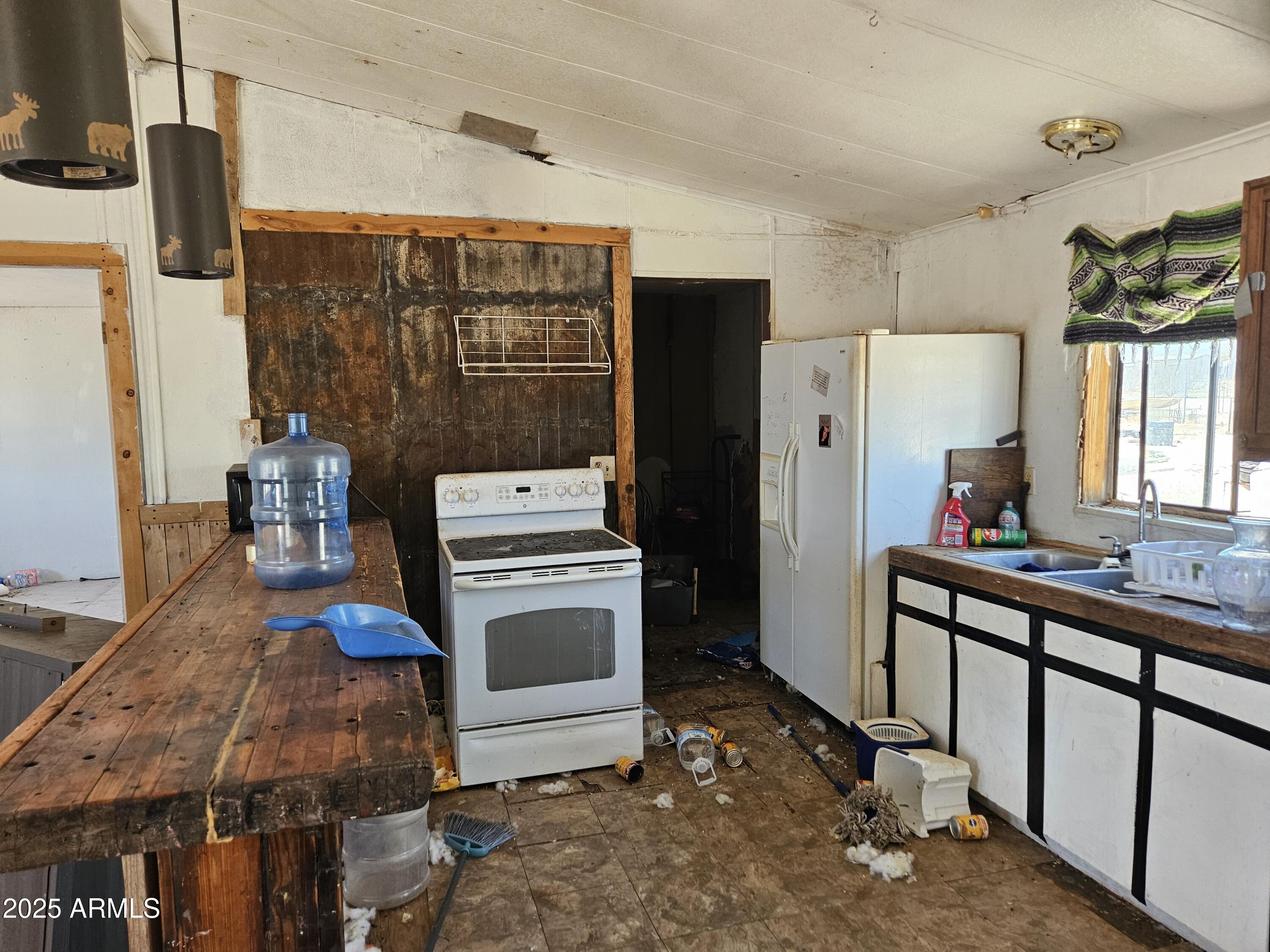 684 South Conejo Road Maricopa, AZ 85139 - Photo 3 of 10 a kitchen that has a refrigerator and a stove