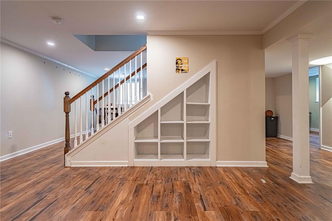 102 Sutton Road Easton, PA 18045 - Photo 56 of 83 Gleaming hardwood floors and a custom under-stairs bookcase elevate this versatile basement space.