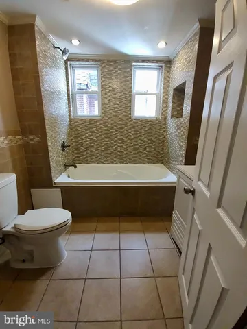 a bathroom with a toilet a sink a mirror a bathtub and shower