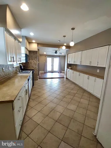 a large kitchen with a sink and cabinets
