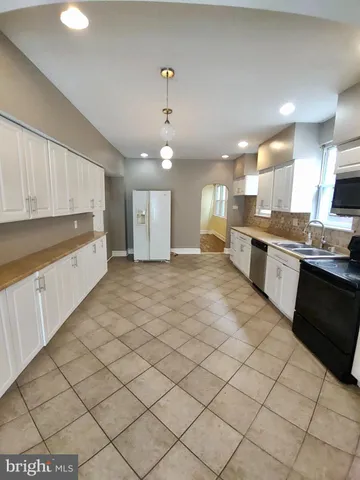 a large kitchen with stainless steel appliances lots of counter space and a sink