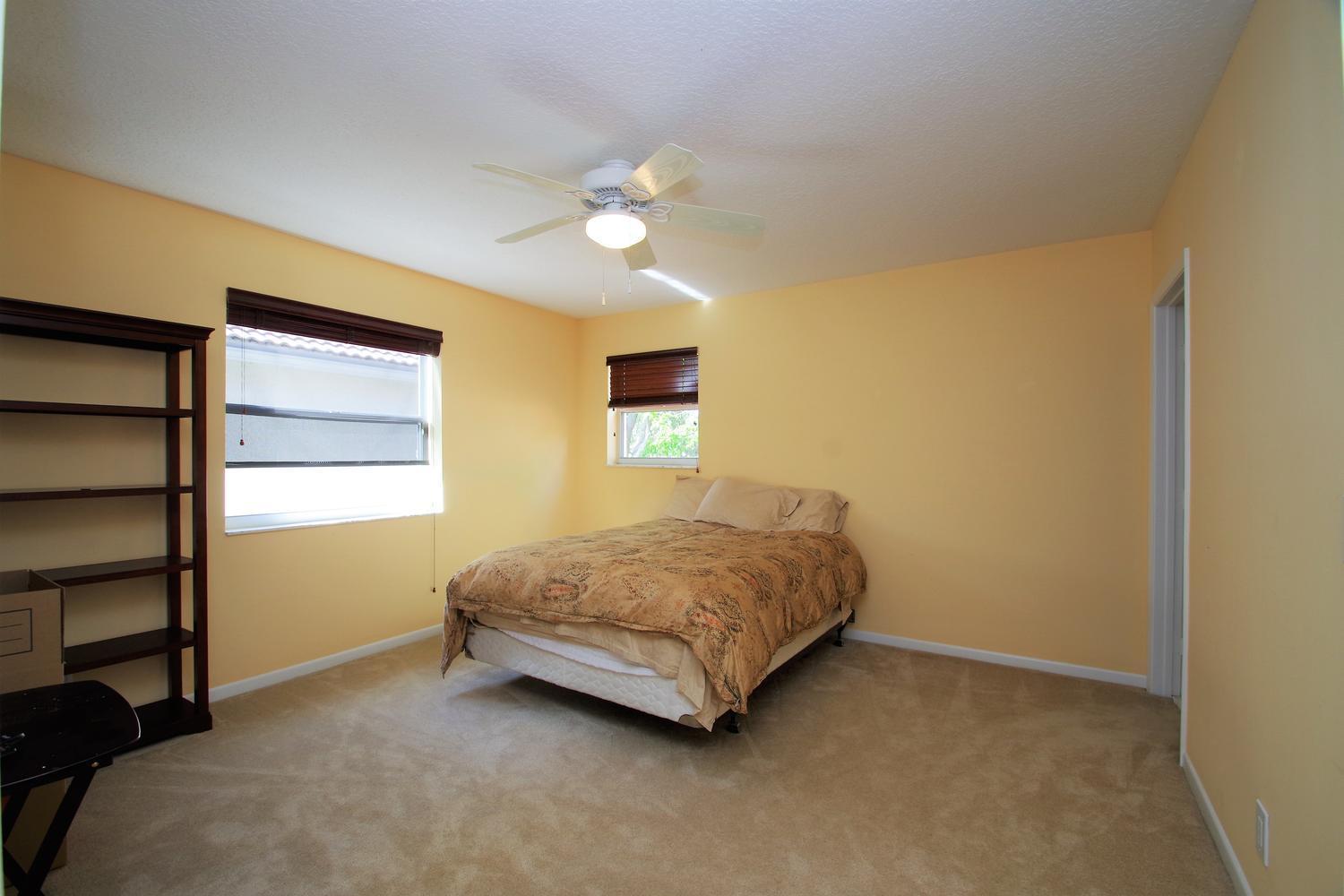 6535 Colomera Drive Boca Raton, FL 33433 - Photo 27 of 36 a spacious bedroom with a bed and a chandelier