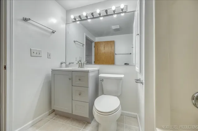 a bathroom with a toilet a sink and mirror