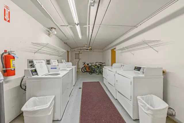 a large white room with a washer dryer and a view of living room