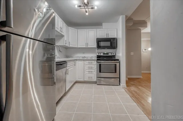 a kitchen with stainless steel appliances a refrigerator sink and microwave