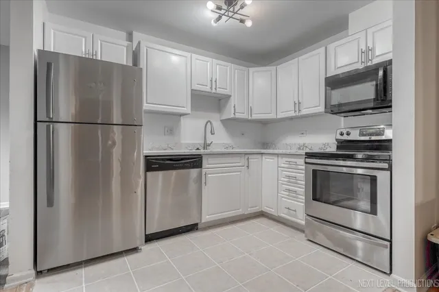 a kitchen with white cabinets and stainless steel appliances