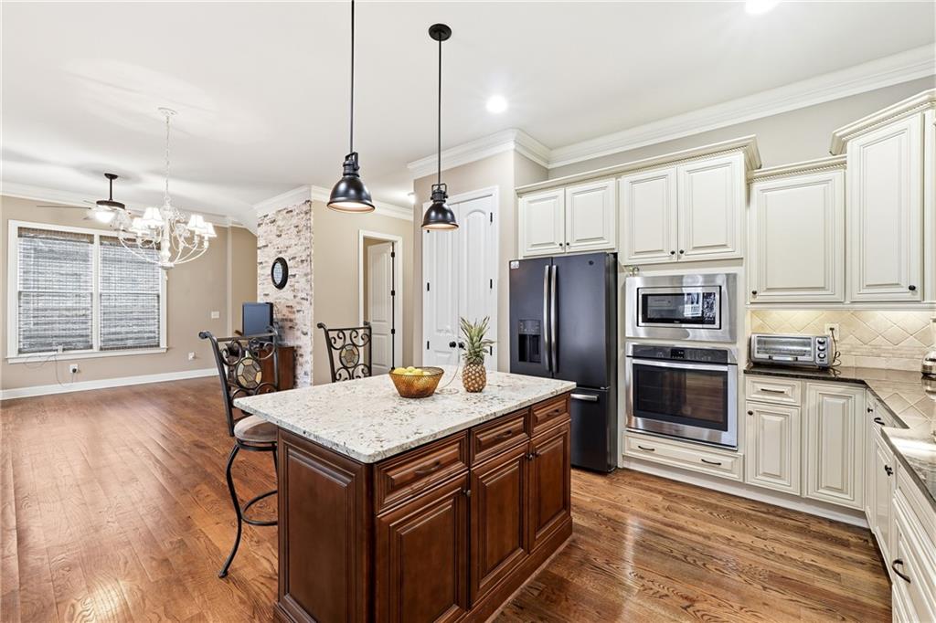 265 Trecastle Square Canton, GA 30114 - Photo 17 of 47 a kitchen with stainless steel appliances granite countertop a kitchen island a stove a table and chairs
