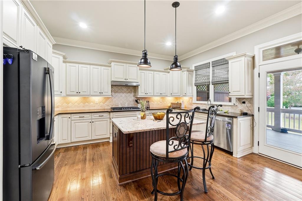 265 Trecastle Square Canton, GA 30114 - Photo 19 of 47 a kitchen with granite countertop a table chairs microwave and cabinets