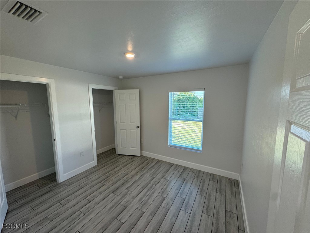 3314 36th Street Southwest Lehigh Acres, FL 33976 - Photo 17 of 23 an empty room with wooden floor and window