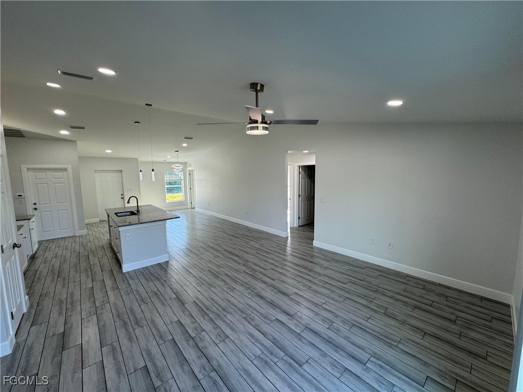 3314 36th Street Southwest Lehigh Acres, FL 33976 - Photo 6 of 23 a view of a living room and kitchen with wooden floor