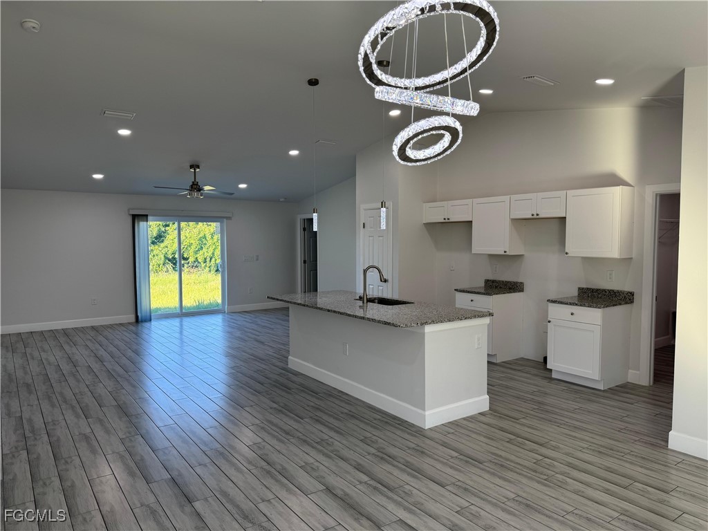 3314 36th Street Southwest Lehigh Acres, FL 33976 - Photo 8 of 23 a kitchen with a wooden floor and a window