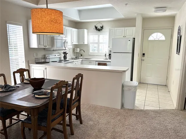 a kitchen with stainless steel appliances granite countertop a stove a sink dishwasher a dining table and chairs