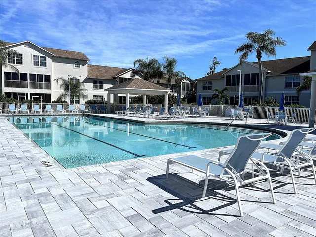 a view of a house with pool and chairs