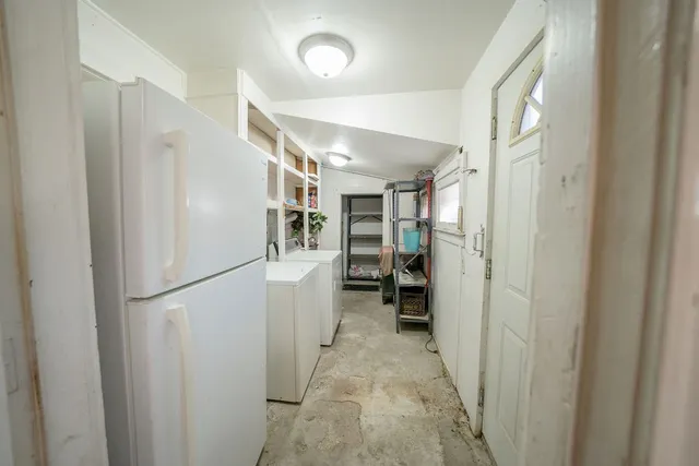 a view of a hallway with closet and a refrigerator