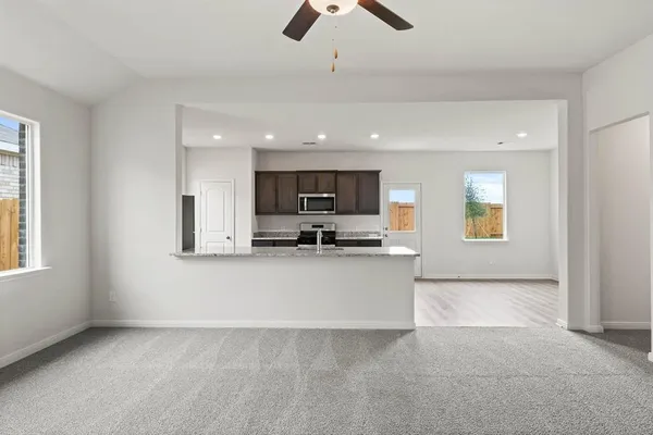 a view of kitchen with microwave a stove and a window