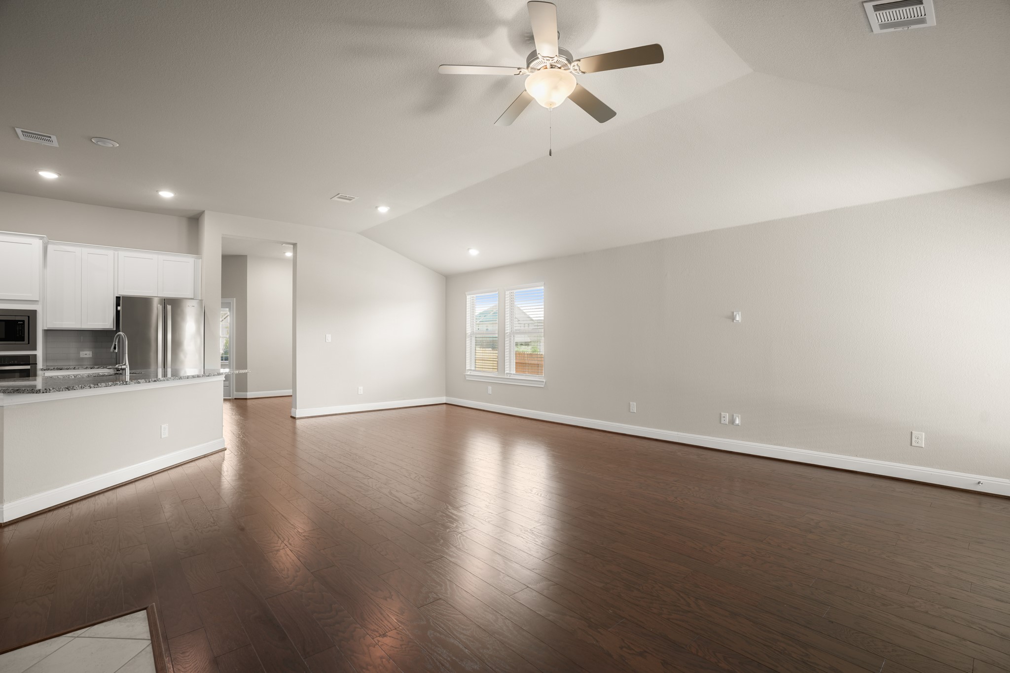 2209 Hat Bender Loop Round Rock, TX 78664 - Photo 7 of 25 an empty room with wooden floor ceiling fan and windows