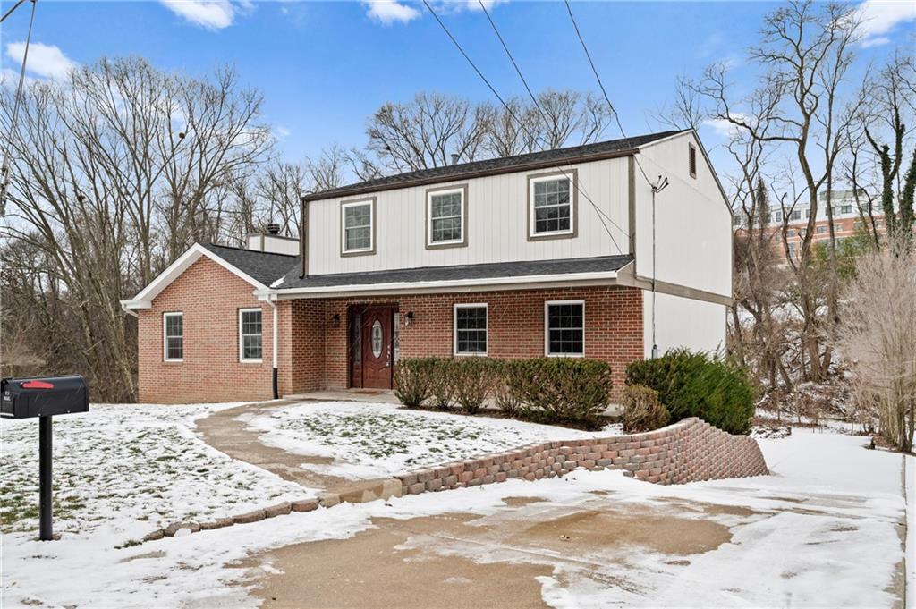 a front view of a house with a yard covered in snow