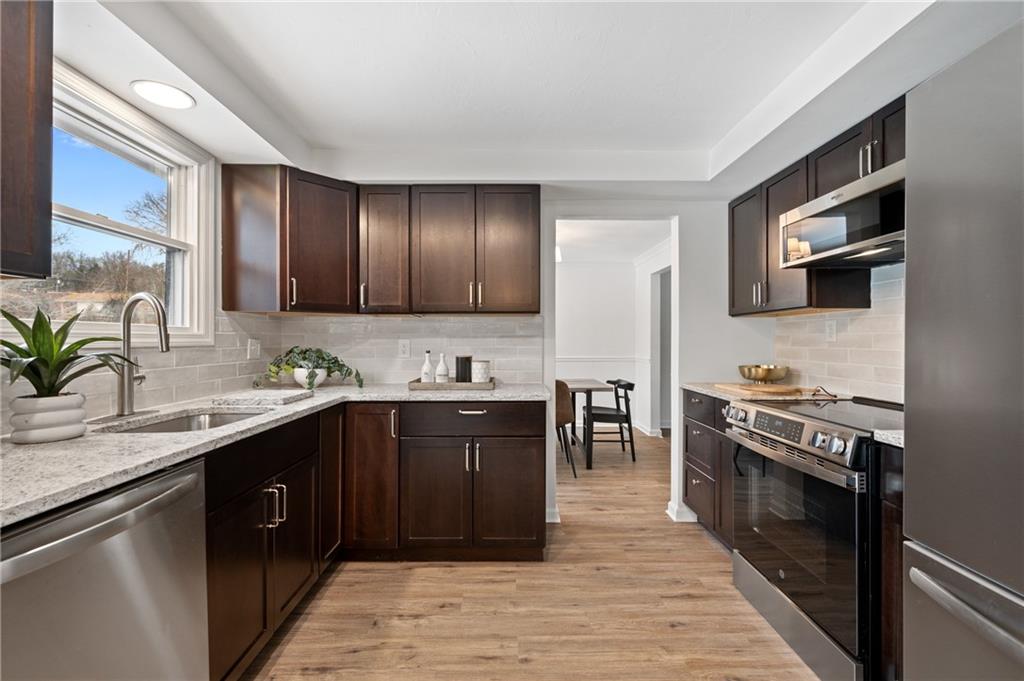 200 Pinchtown Road Pittsburgh, PA 15236 - Photo 6 of 26 a kitchen with a stove sink and cabinets