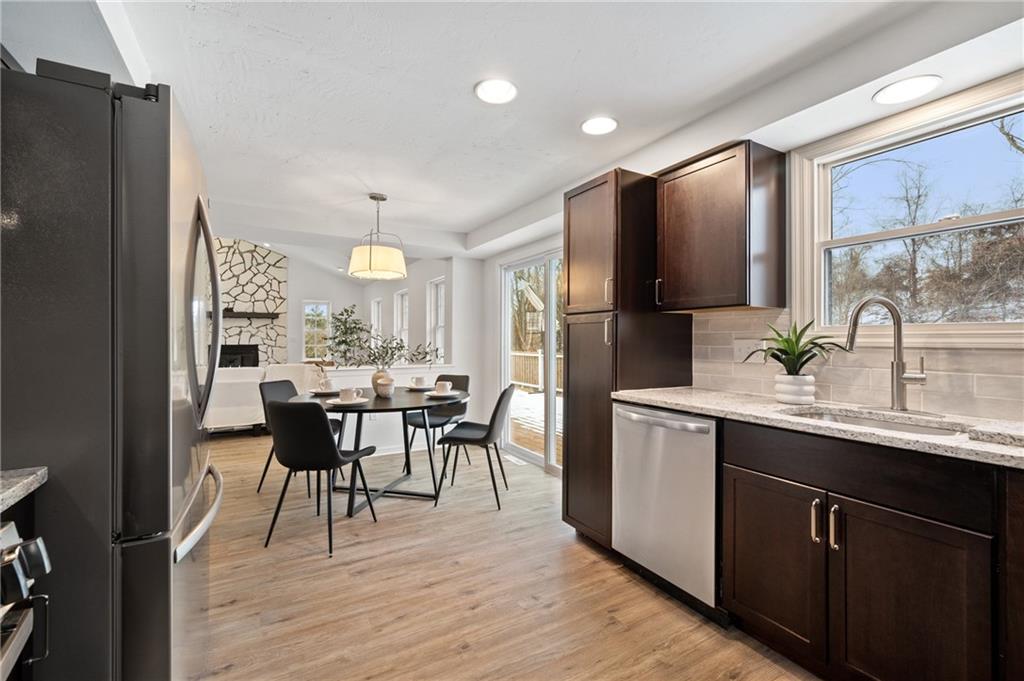 200 Pinchtown Road Pittsburgh, PA 15236 - Photo 8 of 26 a kitchen with stainless steel appliances a dining table chairs refrigerator and sink