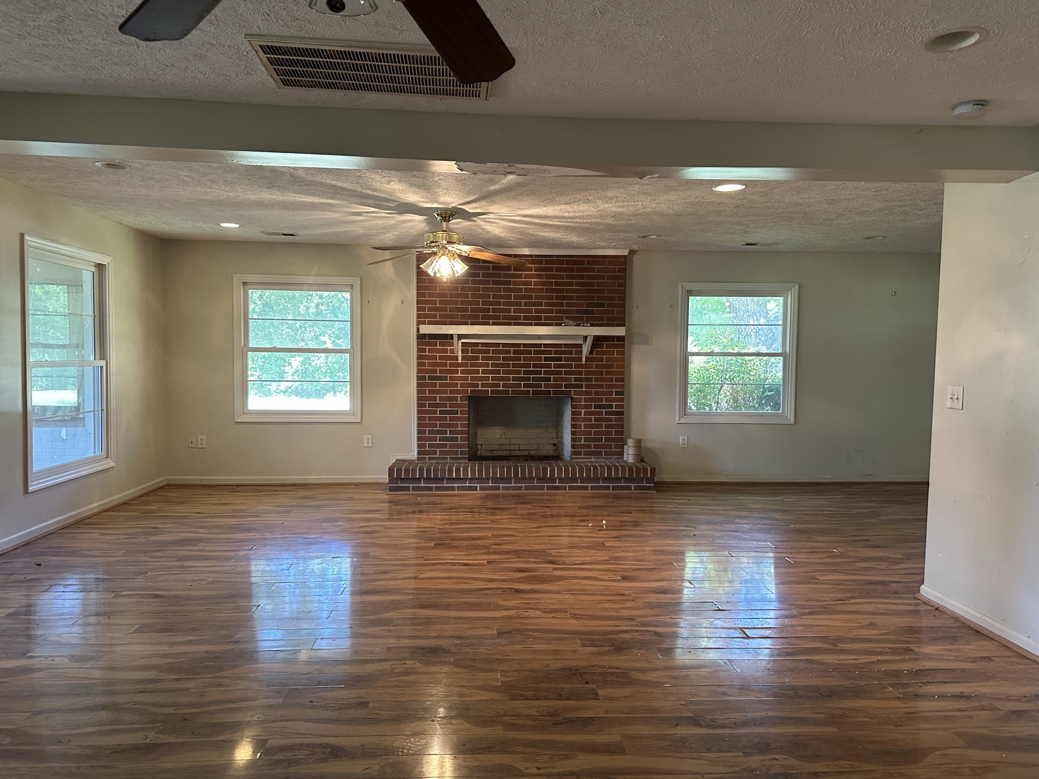 10026 Mona Road Murfreesboro, TN 37129 - Photo 47 of 64 an empty room with wooden floor fireplace and windows