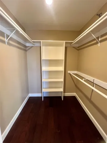 a view of walk in closet with empty racks