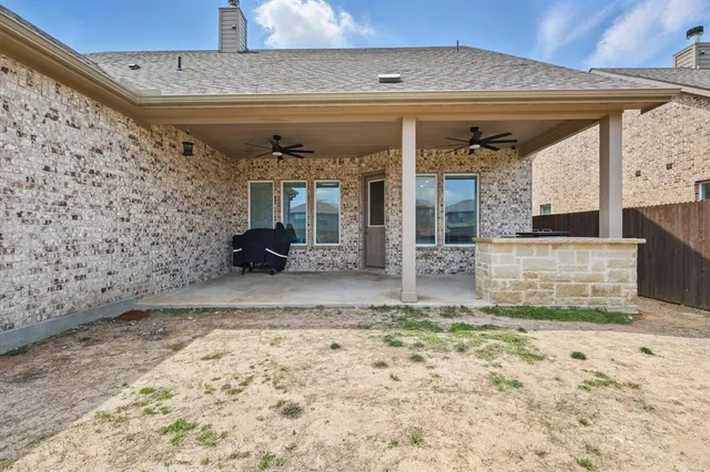 a view of a brick house with a big yard and large trees
