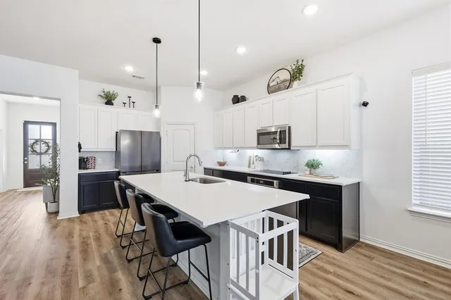 a large kitchen with a table and chairs