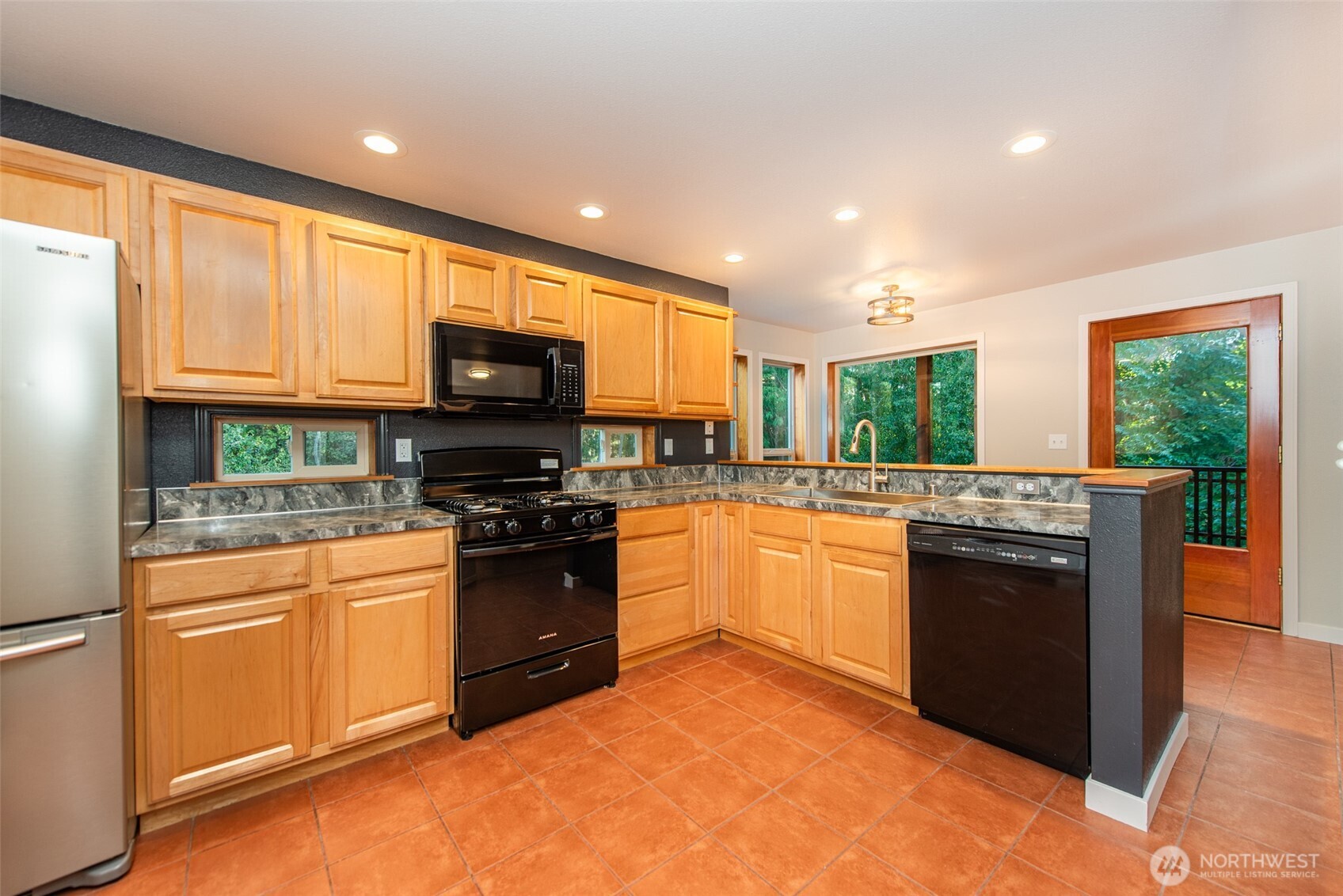 62 Pierson Lane Sequim, WA 98382 - Photo 11 of 40 a kitchen with stainless steel appliances granite countertop a stove top oven a sink dishwasher and a refrigerator with wooden floor