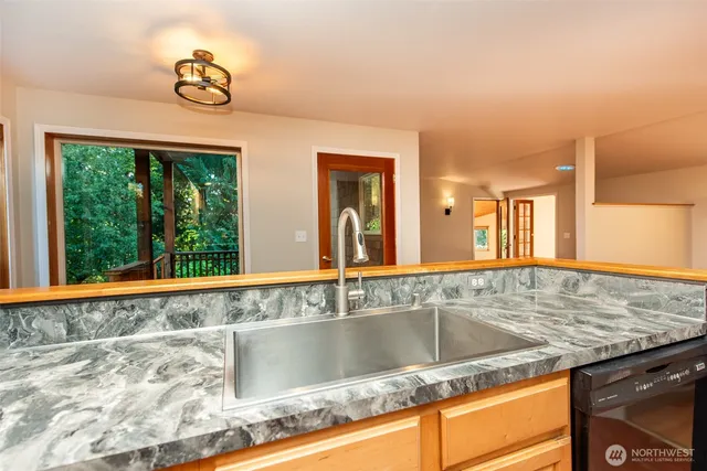 a bathroom with a granite countertop sink and a large mirror