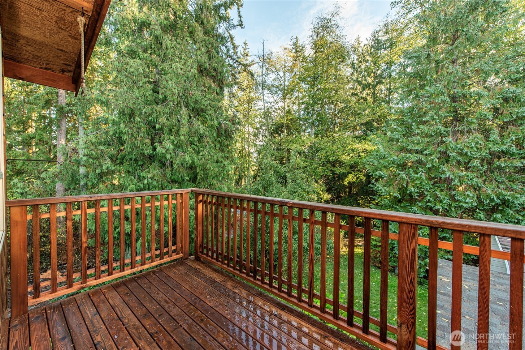 62 Pierson Lane Sequim, WA 98382 - Photo 29 of 40 a balcony with wooden floor and trees in the back